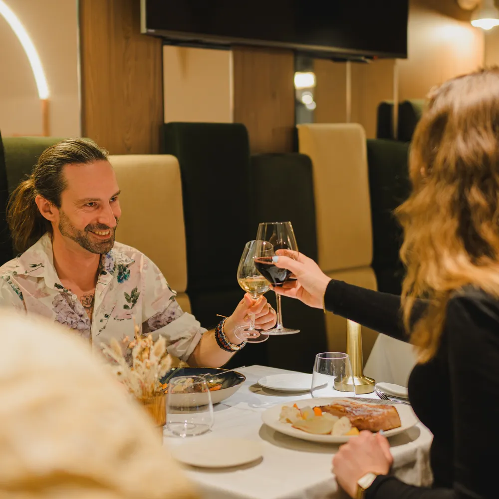Guests raise their wine glasses around a table at L'Alambic