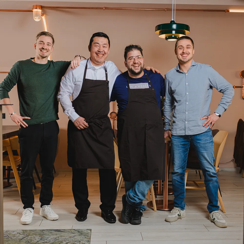 Group portrait of four members of L'Alambic in the dining room